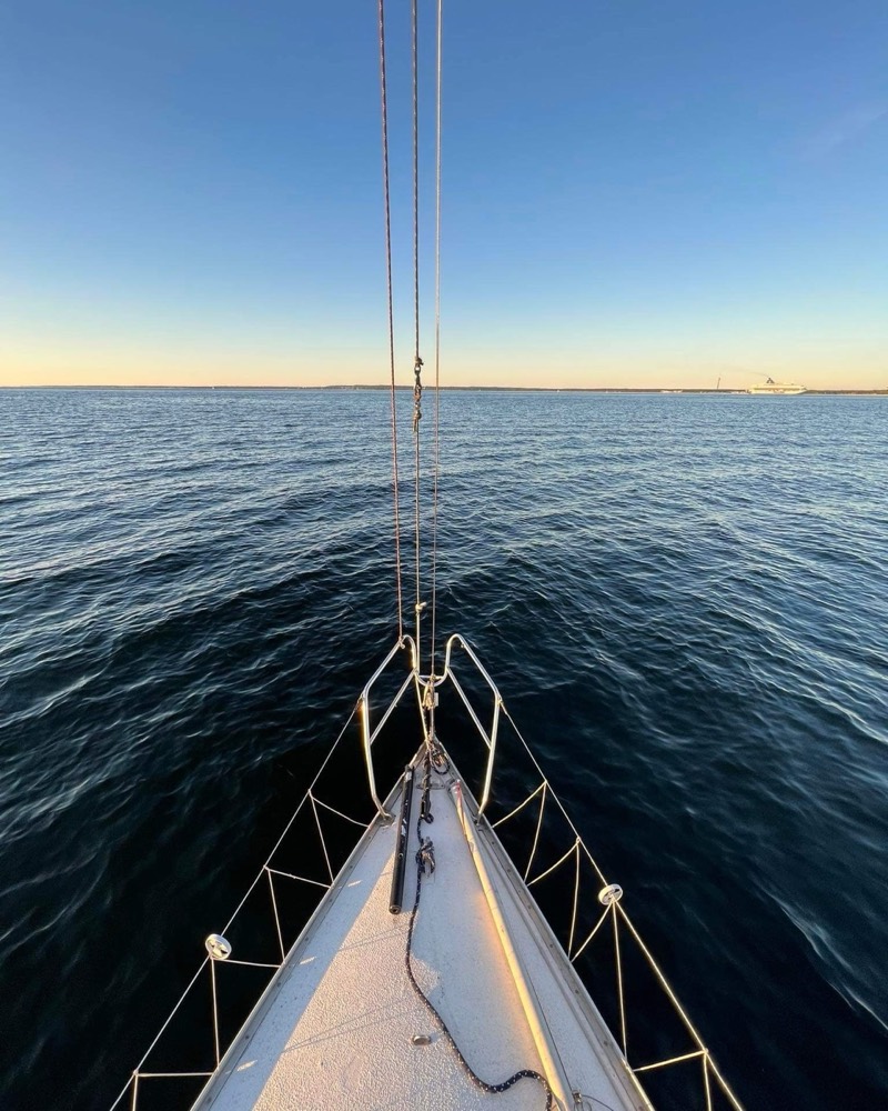 The bow of a sailboat pointed toward open water